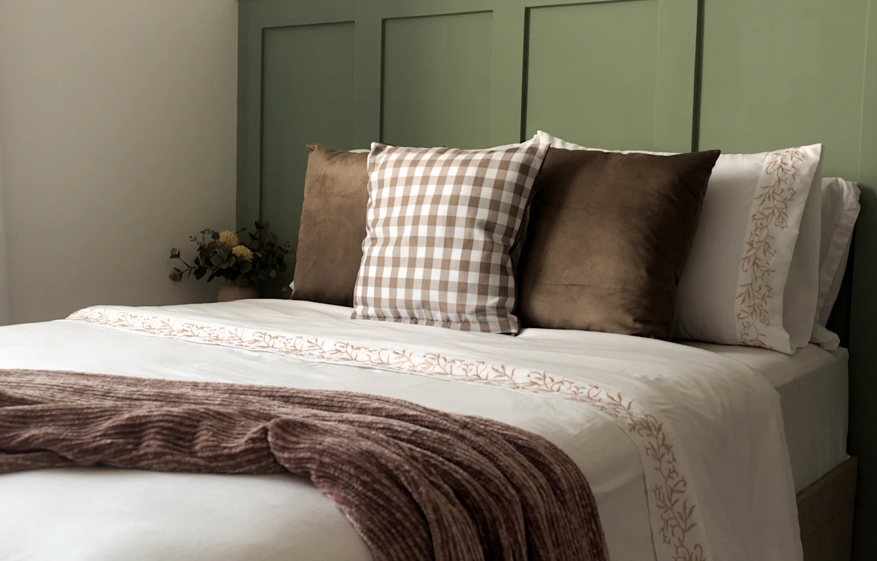 The Lake Room, with olive walls, gingham cushions and a brown wool blanket