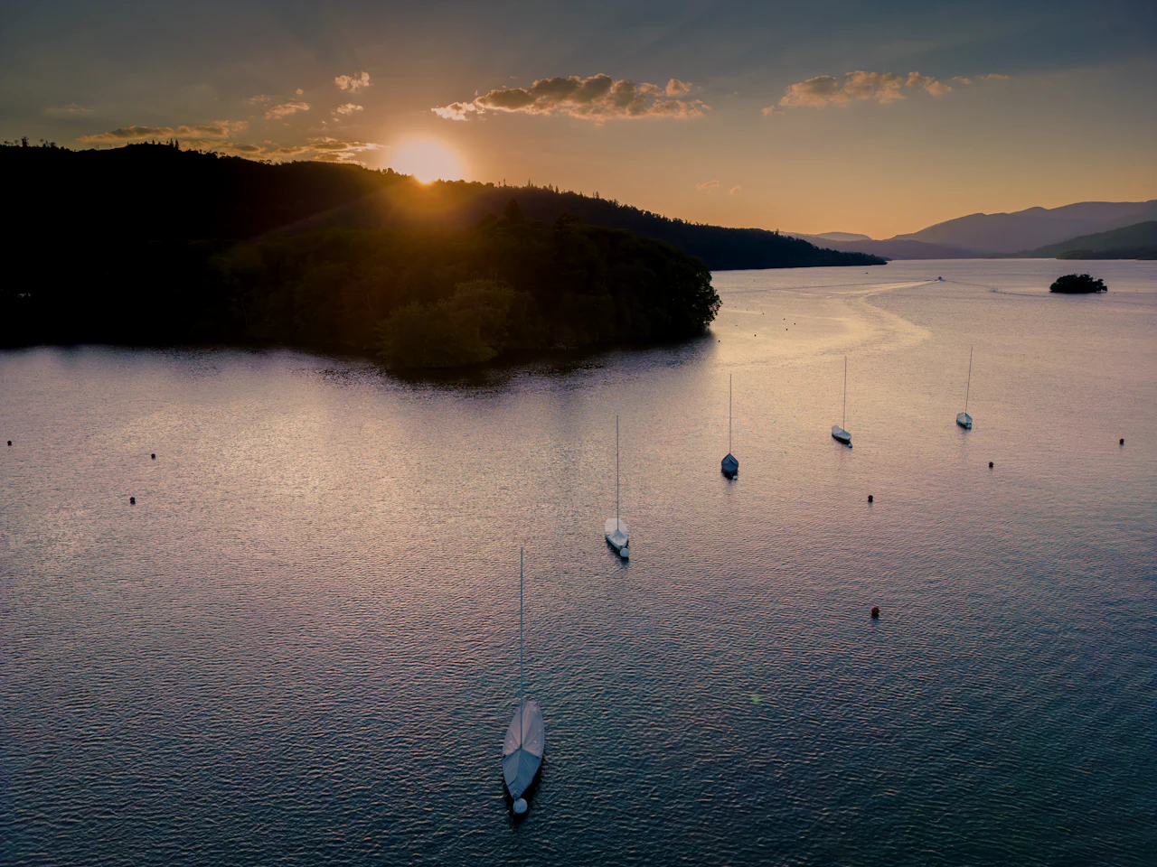 Boats on the water at Windermere in golden haze