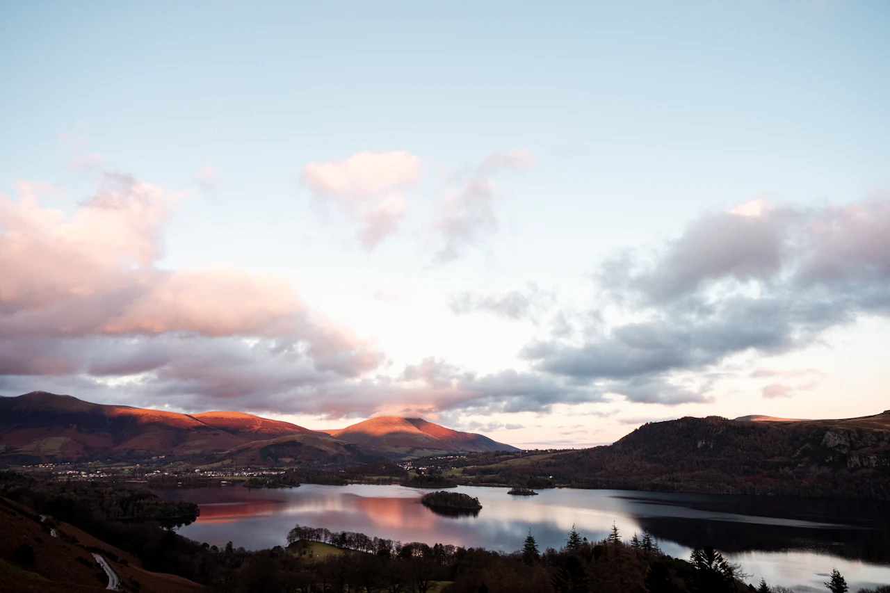 Derwentwater at dusk, with pink cloud above the fells and still water below