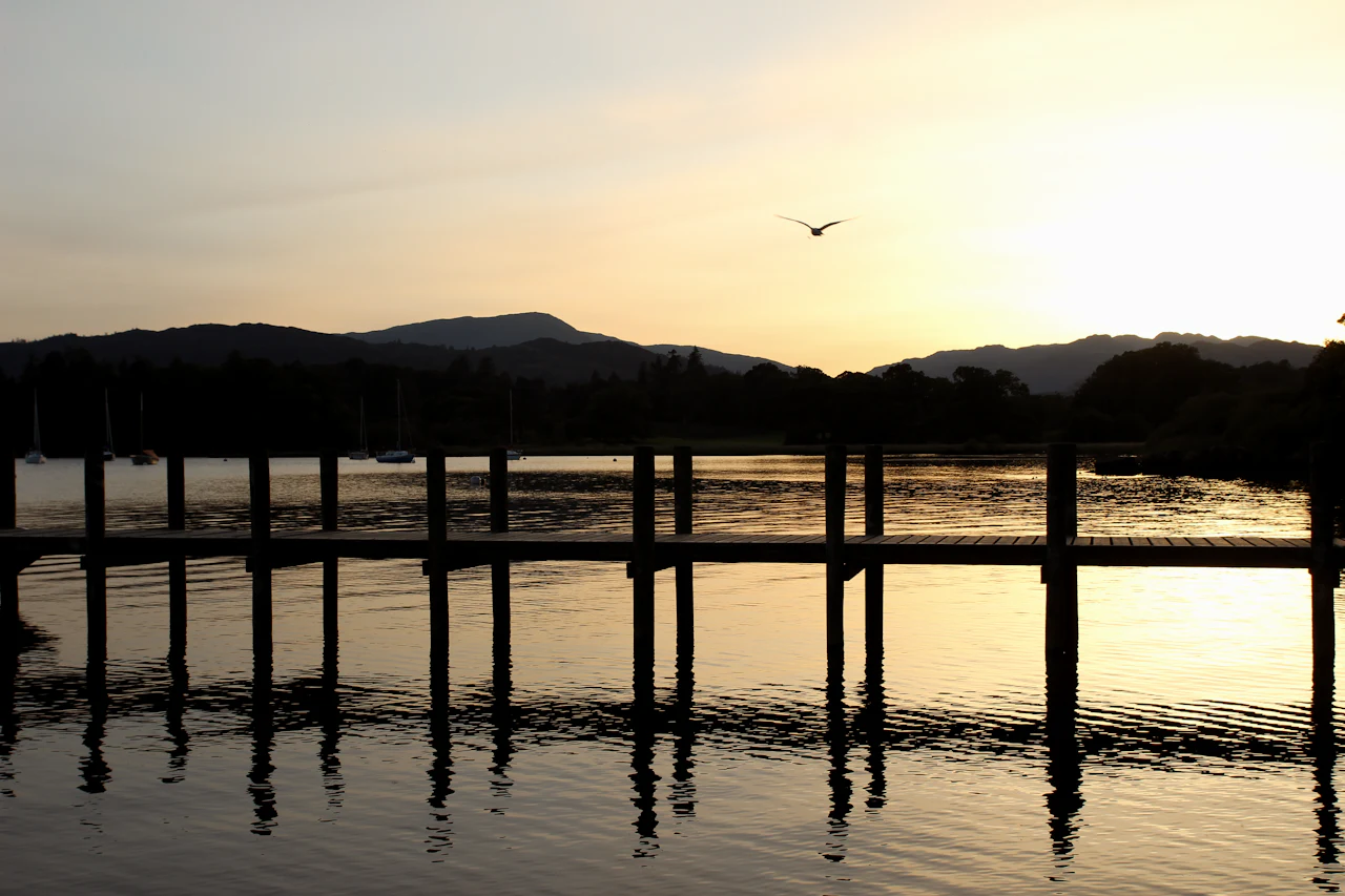 Sunset over Windermere, with the posts of an old jetty silhouetted against the water